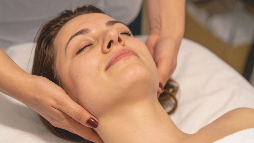 Fisioterapeuta aplica técnica de terapia manual em paciente que apresenta o rosto relaxado 