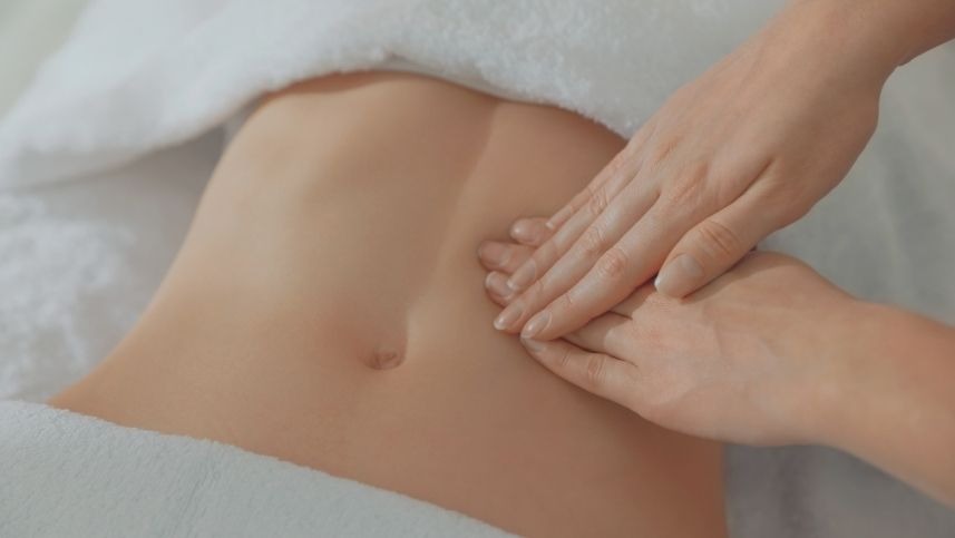 Fisioterapeuta aplica técnica de terapia manual no abdômen de uma paciente